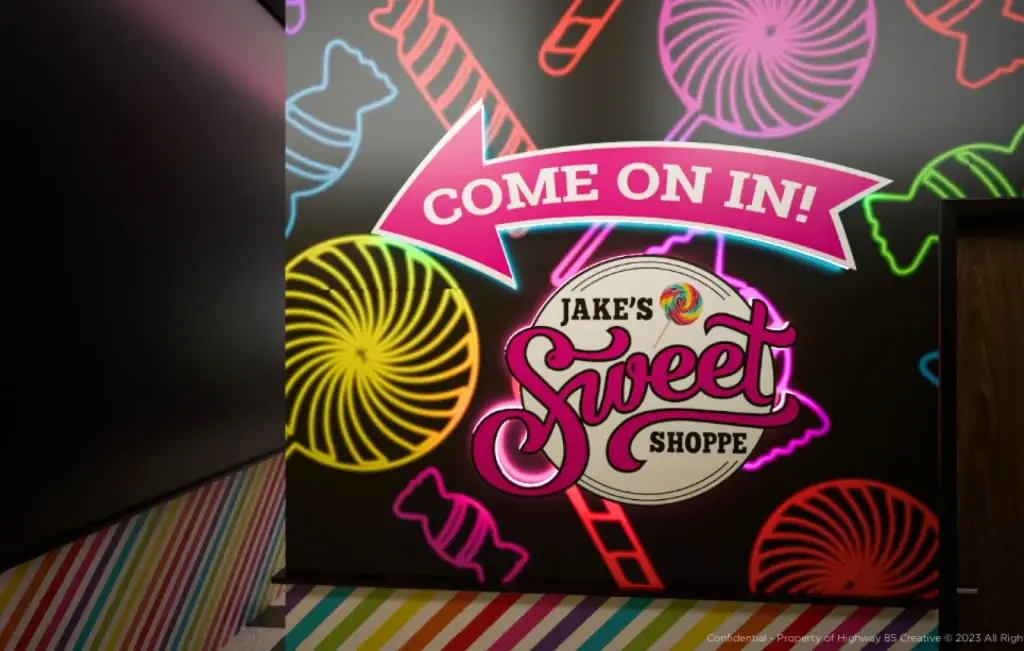 Bright neon sign at Jake's Sweet Shoppe reading 'Sweet Shoppe'.