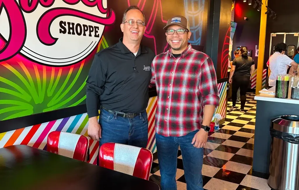 Two men smiling and enjoying the atmosphere at Jake's Sweet Shoppe